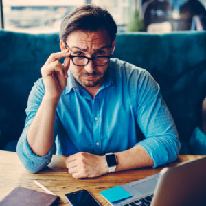 What's the plan? A seated man peering over his glasses asks the question.